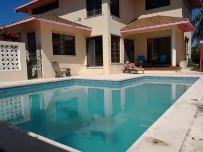 How To Choose A Pool Builder : Enjoying sun next to a garden underground swimming pool